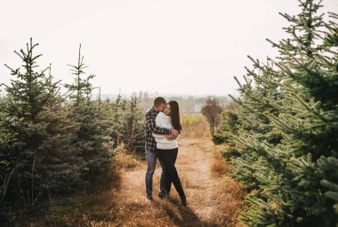 Sarılma n orta açılış köknar ağacının genç çift