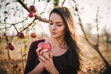 Bir büyük kırmızı elma elma bahçesi içinde olan güzel kadın portresi