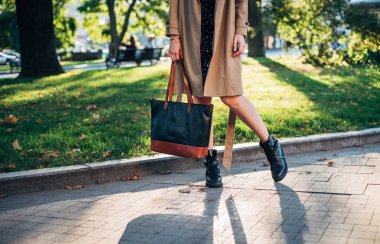 Atış deri çanta ile eski şehir merkezi üzerinde yürüyen kadın bacakları yukarı kapatın