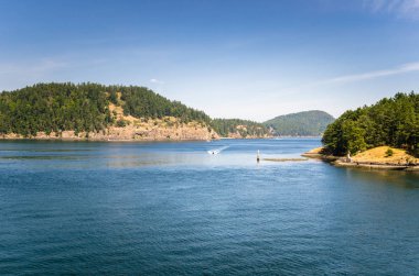 Mavi gökyüzünün altında ormanlık adalar arasında Boğazı