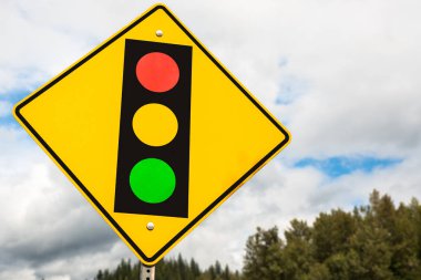 Sarı trafik işaretleri ile bulutlu gökyüzü arka plan uyarı sürücüleri trafik ışıkları devam karşı.