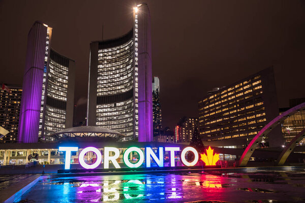 Торонто, штат Огайо, Канада - 17 ноября 2017 года: Новая ратуша и Знак Торонто на площади Натана Филлипса ночью. Новая ратуша - одна из самых примечательных достопримечательностей города
.