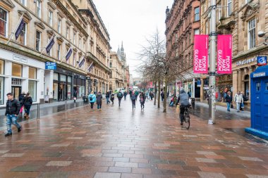 Glasgow, İngiltere - 07 Mart 2018: şehir merkezinde dükkanlar ile bulutlu bir kış gününde kaplı bir yaya cadde boyunca Strolling insanlar.