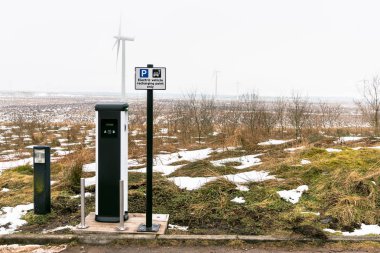 Sisli bir kış gününde İskoç dağlık arka planda bir rüzgar çiftliği ile dur arabalar için kontör yükleme noktası. Ekoloji ve Rewable enerji kavramı.