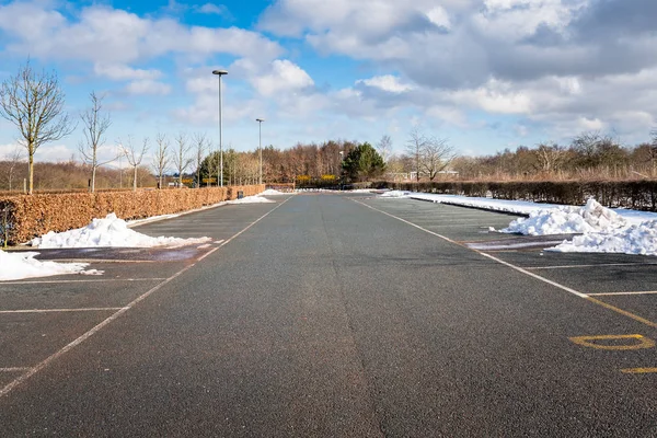 Verlaten Parkeerplaats Vrijgemaakt Van Sneeuw Onder Blauwe Hemel Met Wolken — Stockfoto