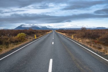 Eğimli bir yol için kar ve düz boş dağlar İzlanda'sonbaharda kaplı.