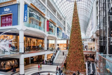 Toronto, ON, Canada - November 20, 2017: Eaton Centre with a tall Christmas Tree.  Eaton Centre is North America's busiest shopping mall, due to extensive transit access, its downtown location and tourist traffic. clipart