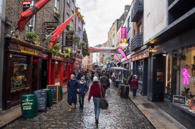 Dublin, İrlanda - 8 Aralık 2018: İnsanlar ünlü Temple Bar Pub yakınındaki eski kentte Temple Bar cadde boyunca Strolling. Temple Bar bir meşgul nehir Dublin şehir merkezinde semtidir.