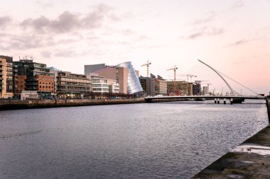 Dublin Docklands manzarası ve alacakaranlık River Liffey kapsayan Modern bir asma köprü