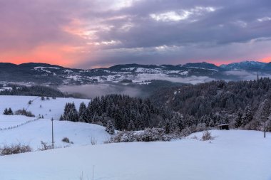Kışın İtalyan Alpleri'nde güzel bir karlı dağ manzarası üzerinde görkemli gün batımı