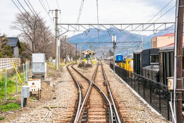 Bulutlu erken bahar gününde Japonya 'da küçük bir tren istasyonu önce parçaları açın