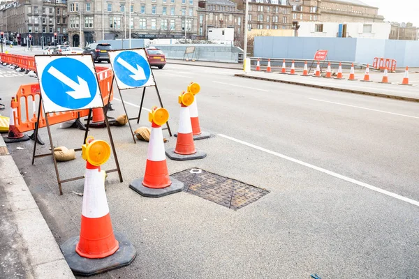 Signs and traffic cones indicating the closure of a lane of a wide street beacuse of roadworks. Dundee, Scotland, UK.