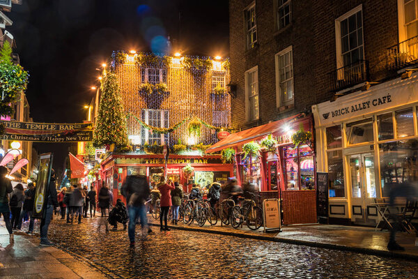 Dublin, Ireland - December 06, 2018: View of famous Temple Bar at night. The Temple Bar is one of the most famous pubs in Dublin. Its history goes back to 1599 when Sir William Temple built his house and gardens here.