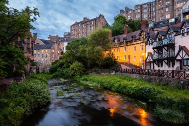 Alacakaranlıkta Edinburgh'un merkezindeki Leith Suyu boyunca uzanan güzel geleneksel binaların manzarası. Dean Village, Edinburgh, İskoçya, İngiltere.