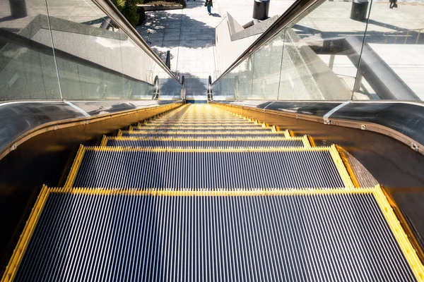 Steps of an outdoor public escalator in a city centre on a sunny day. Tokyo, Japan.