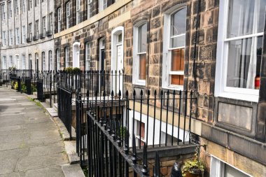 Bir taş kaldırım boyunca metal çitler ile bazı geleneksel şehir evlerinin girişinin görünümü. Edinburgh, İskoçya, İngiltere.