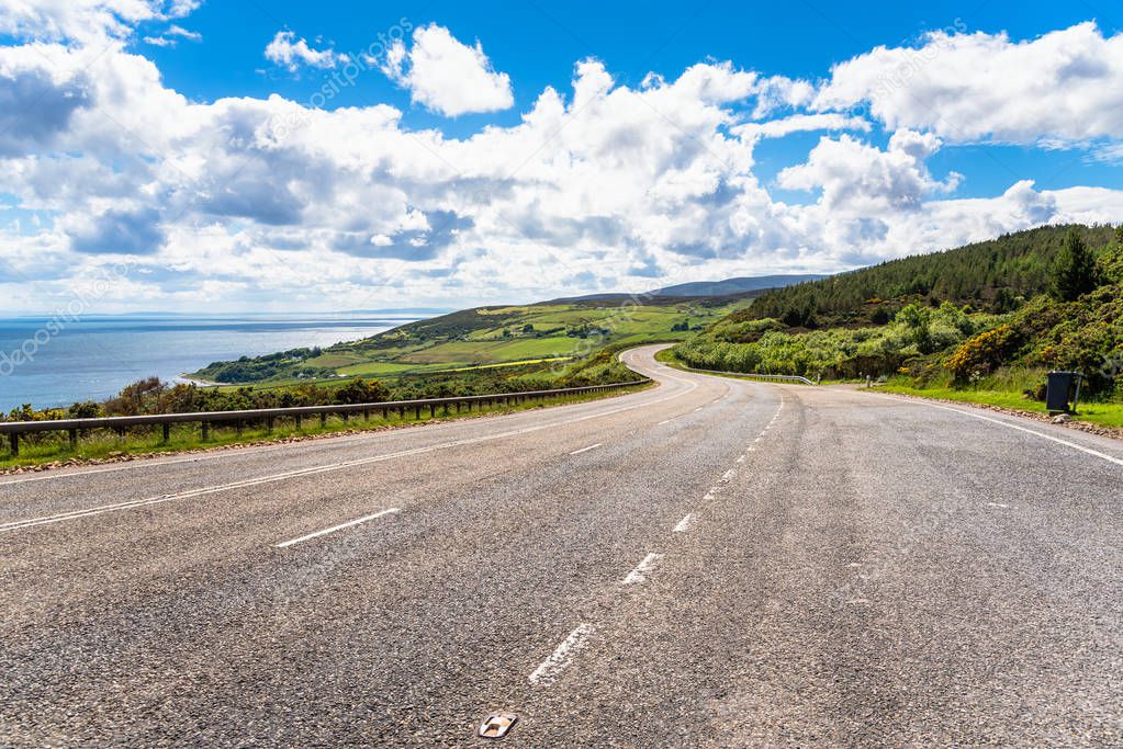 Wide winding road along the coast on a clear spring day. Scotland, UK.