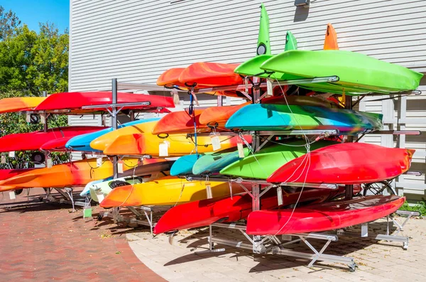 五彩缤纷的皮划艇和独木舟在一个阳光明媚的秋日在一家户外设备商店外面大减价 — 图库照片