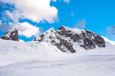Avrupa Alplerinde dumanlı kayalık tepeler ve kış gününde mavi gökyüzü