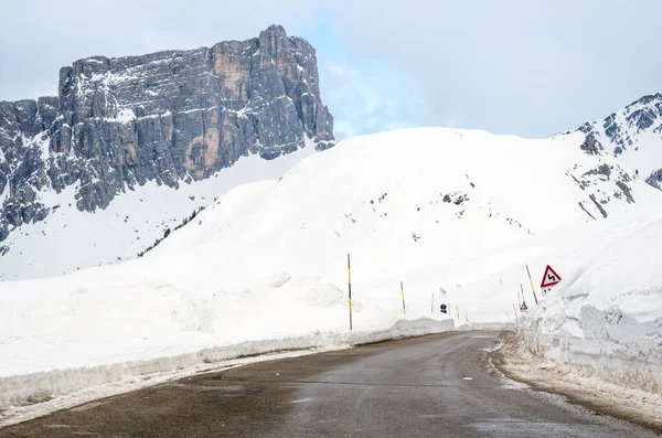 冬のヨーロッパアルプスの雪の空の山道をクリアします 背景には高くそびえる山が見える — ストック写真