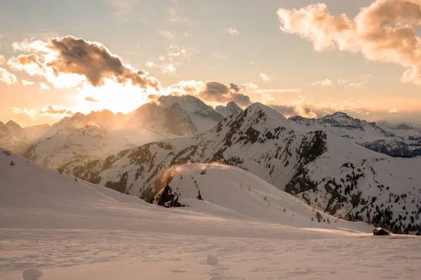 冬にはヨーロッパアルプスの雄大な雪に覆われた山の上に夕日 手前には雪の草原が広がっている — ストック写真