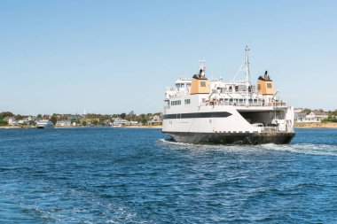 Car ferry sailing into a harbour on a clear autumn day. Hyannis, Cape Cod, MA, USA. clipart