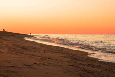 Sonbaharda kumlu bir plajda sersemletici turuncu gün batımı. Provincetown, MA, ABD.