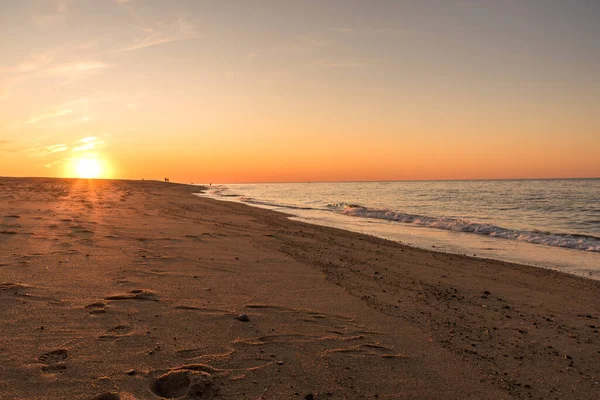 Zachodzące Słońce Nad Piękną Piaszczystą Plażą Ludzie Spacerujący Wzdłuż Plaży — Zdjęcie stockowe