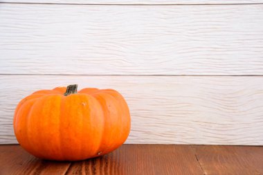 Tahta bir masada küçük bir balkabağı. Uzayı kopyala ve seçici odaklan. Cadılar Bayramı ve Şükran Günü konsepti.