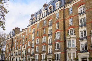 Parçalı bulutlu bir kış gününde geleneksel tuğladan bir apartman binasının ön cephesi. Londra, İngiltere, İngiltere.