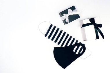 Siyah beyaz hediye kutuları, beyaz arka planda el yapımı yüz maskeleri..