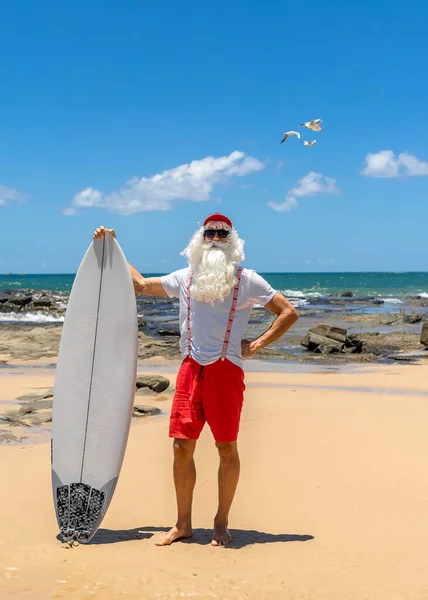 Kerstman houdt geschenkdozen met de oceaan op backgraund Stockafbeelding