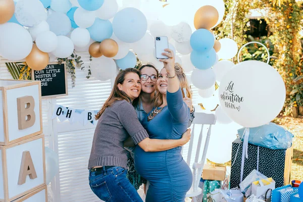 Vrouwelijke vrienden nemen selfie met zwangere vrouw op een baby shower Rechtenvrije Stockfoto's