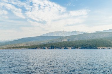 Sabah sis ufukta deniz kıyısı ve dağlar