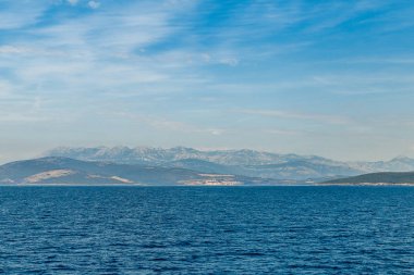 Sabah sis ufukta deniz kıyısı ve dağlar