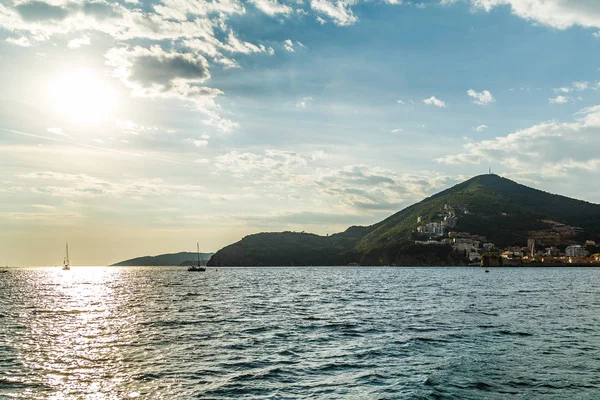 Vista de la costa cerca de la ciudad de Budva desde el mar contra el sol poniente — Foto de Stock