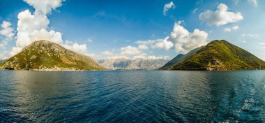 Körfezin girişinde yeşil bitki örtüsü ile kaplı iki yüksek tepe