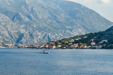 Kotor Körfezi'ndeki yüksek dağların eteklerindeki sahildeki şehir 