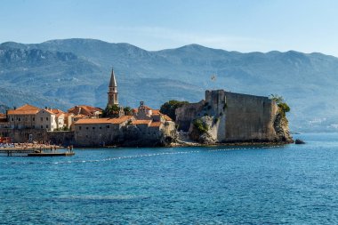 Budva şehrinin görünümü sabah kıyıdan, dağın ufkunda