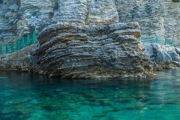 Stony shore at the edge of the sea, light green water and stones — Stock Photo, Image