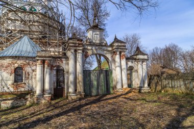 Rus taşrasında kilisenin etrafında çit, kötü durumda tuğla sütunlar