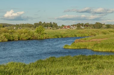 Güneşli bir günde yeşil bankalar ile Düz nehir