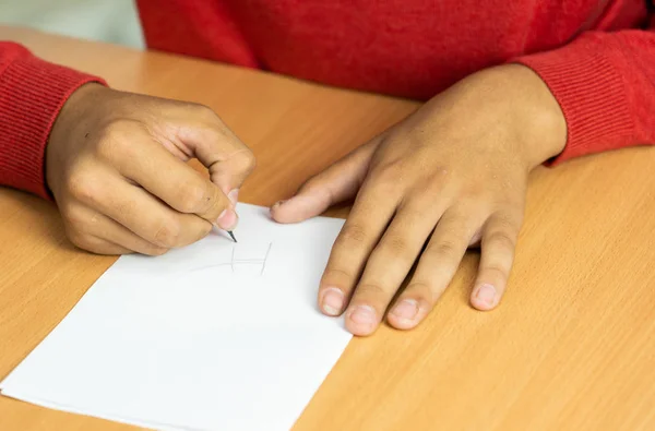 Adolescente escribe a lápiz en una hoja blanca —  Fotos de Stock