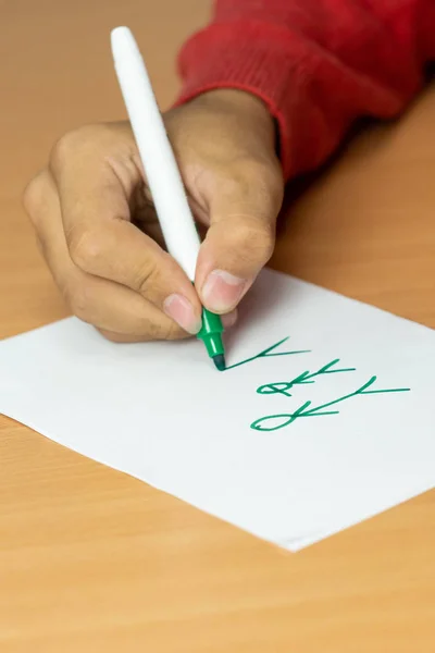 genç beyaz bir levha üzerinde bir işaretçi çizer