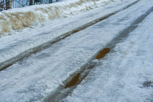Straße mit Schnee und Eis mit Spurrillen bedeckt — Stockfoto