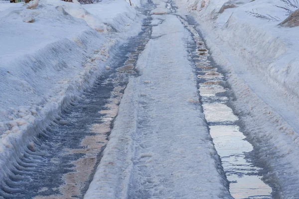 Kış yolu karla, buzla kaplı su birikintileri ve monotonluklarla — Stok fotoğraf