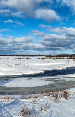 Bir kış gününde nehir kısmen buzla kaplı, dikey çerçeveyle.