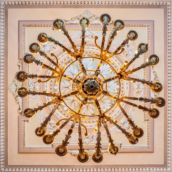 Kültür Merkezi 'nin koridorunda alçıyla süslenmiş tavanın altında parlak bir avize var.