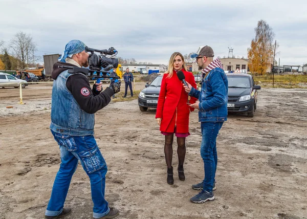 Giornalisti televisivi intervistano le ragazze alle corse automobilistiche su uno sfondo di auto in una giornata autunnale — Foto Stock