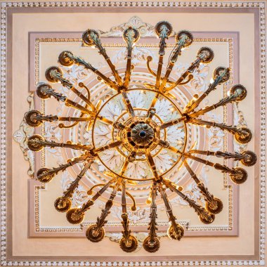 Kültür Merkezi 'nin koridorunda alçıyla süslenmiş tavanın altında parlak bir avize var.